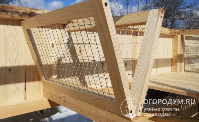 Ясельная кормушка, сделанная в домашних условиях из деревянного бруса и крупноячеистой сетки